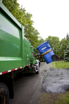 Driver securing a waste vehicle and wearing high-visibility PPE