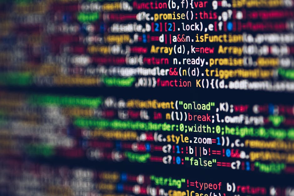 A close-up digital photograph of a computer screen displaying lines of code in a text editor, with syntax highlighting in various colors including yellow, red, blue, and green. The code appears to be 